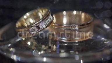 金色结婚戒指。 环上的光的灌注.. 黄金结婚戒指